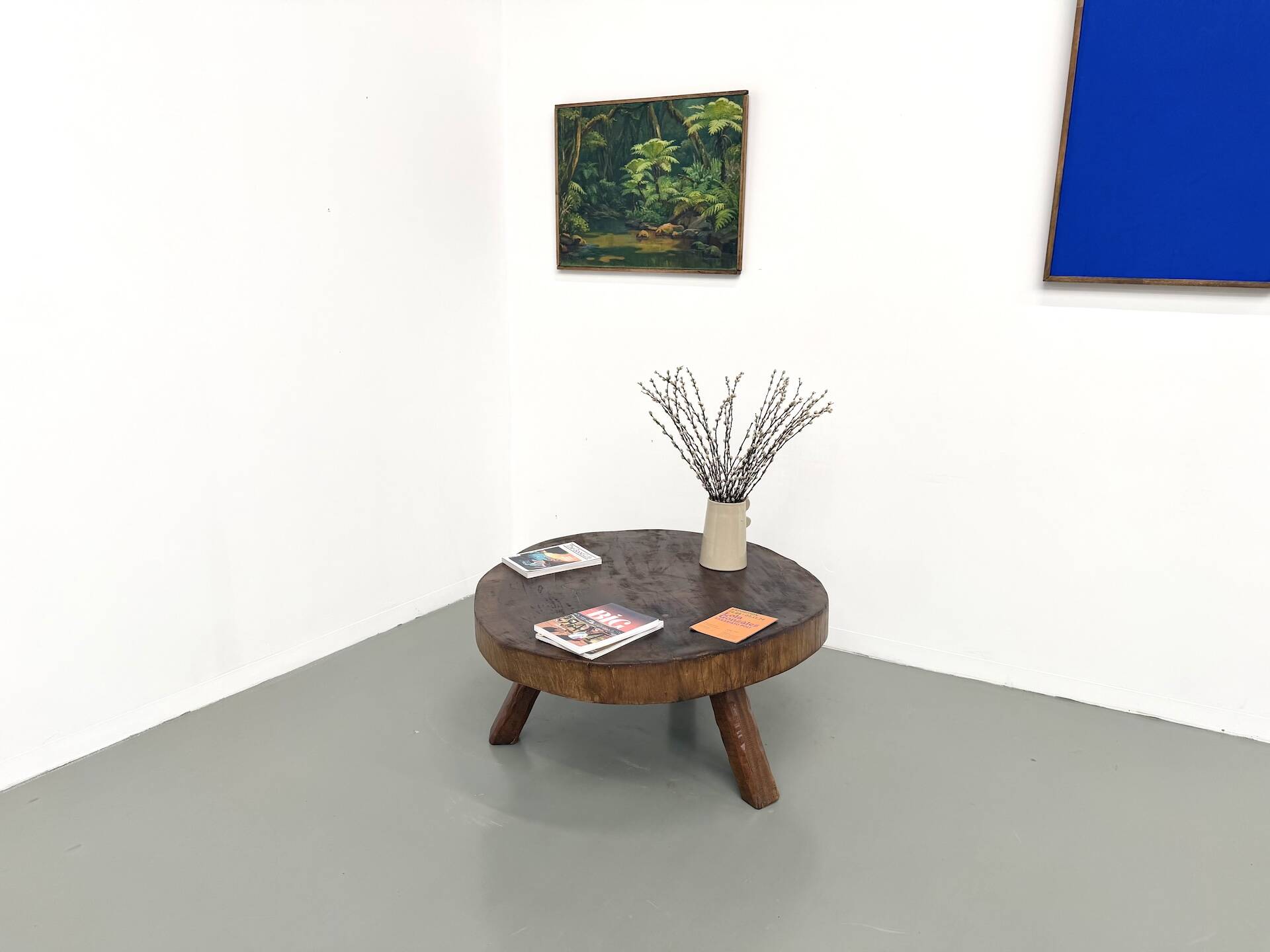 Brutalist coffee table in solid teak, monolithic slab, tripod base.