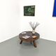 Brutalist coffee table in solid teak, monolithic slab, tripod base.