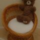 Wicker armchair with a high back and its boucle fabric cushion.