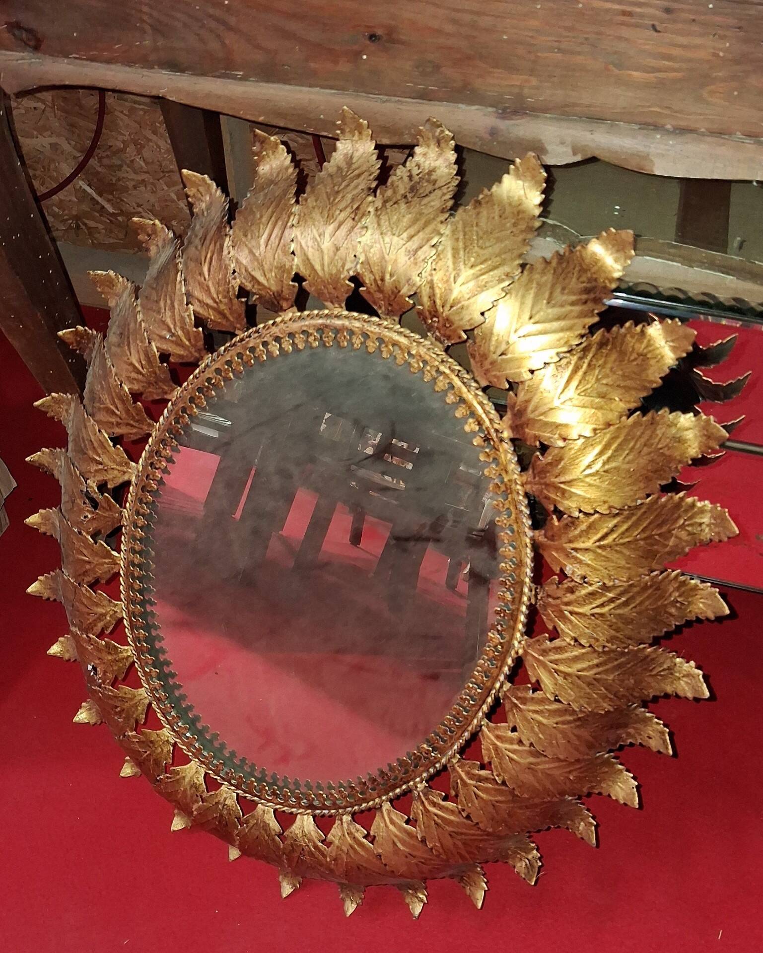 Golden metal sun mirror with leaf decoration