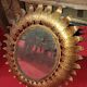 Golden metal sun mirror with leaf decoration