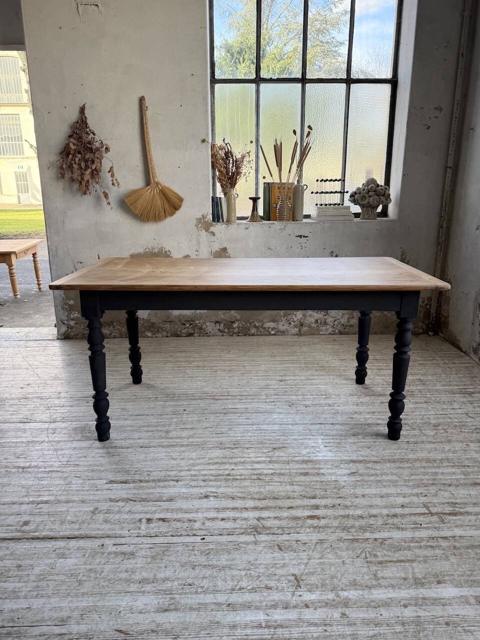 Oak farmhouse table with turned black legs.