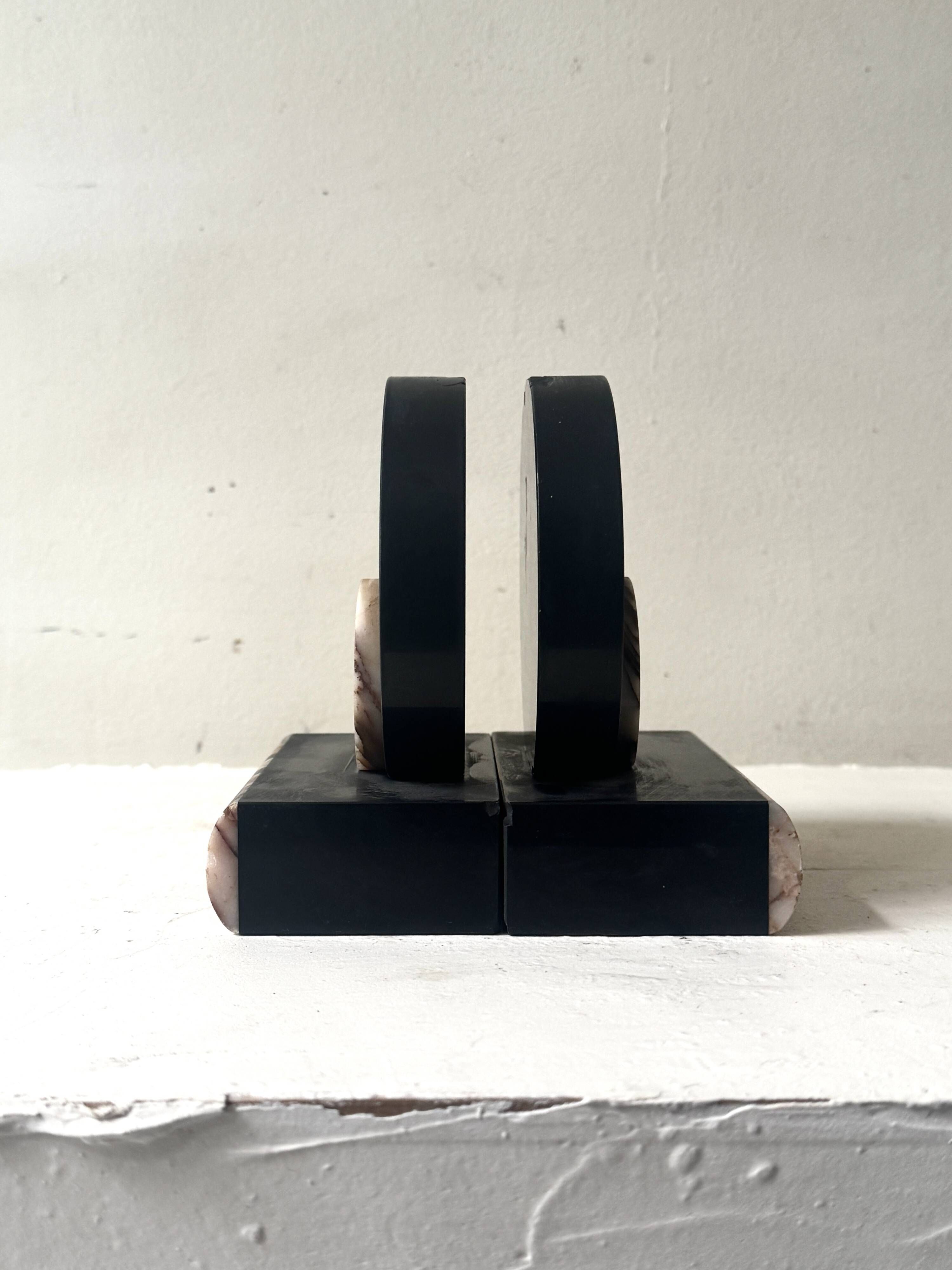Art Deco bookends with a circular design in black and pink marble.