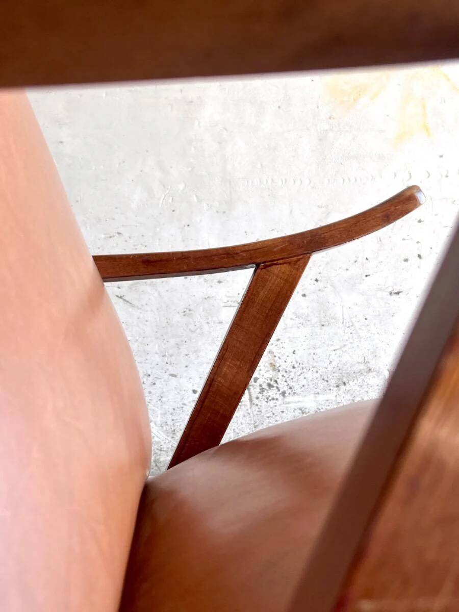 Vintage armchair from the 1950s in cognac leather and dark wood — modernist lounge chair.
