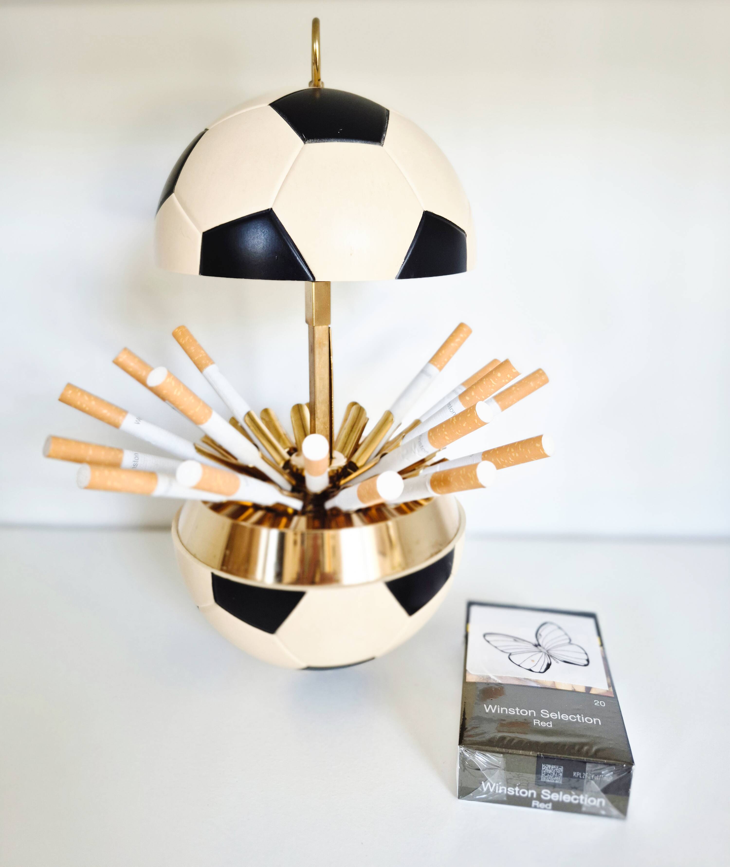 Vintage cigarette dispenser in the shape of a football.