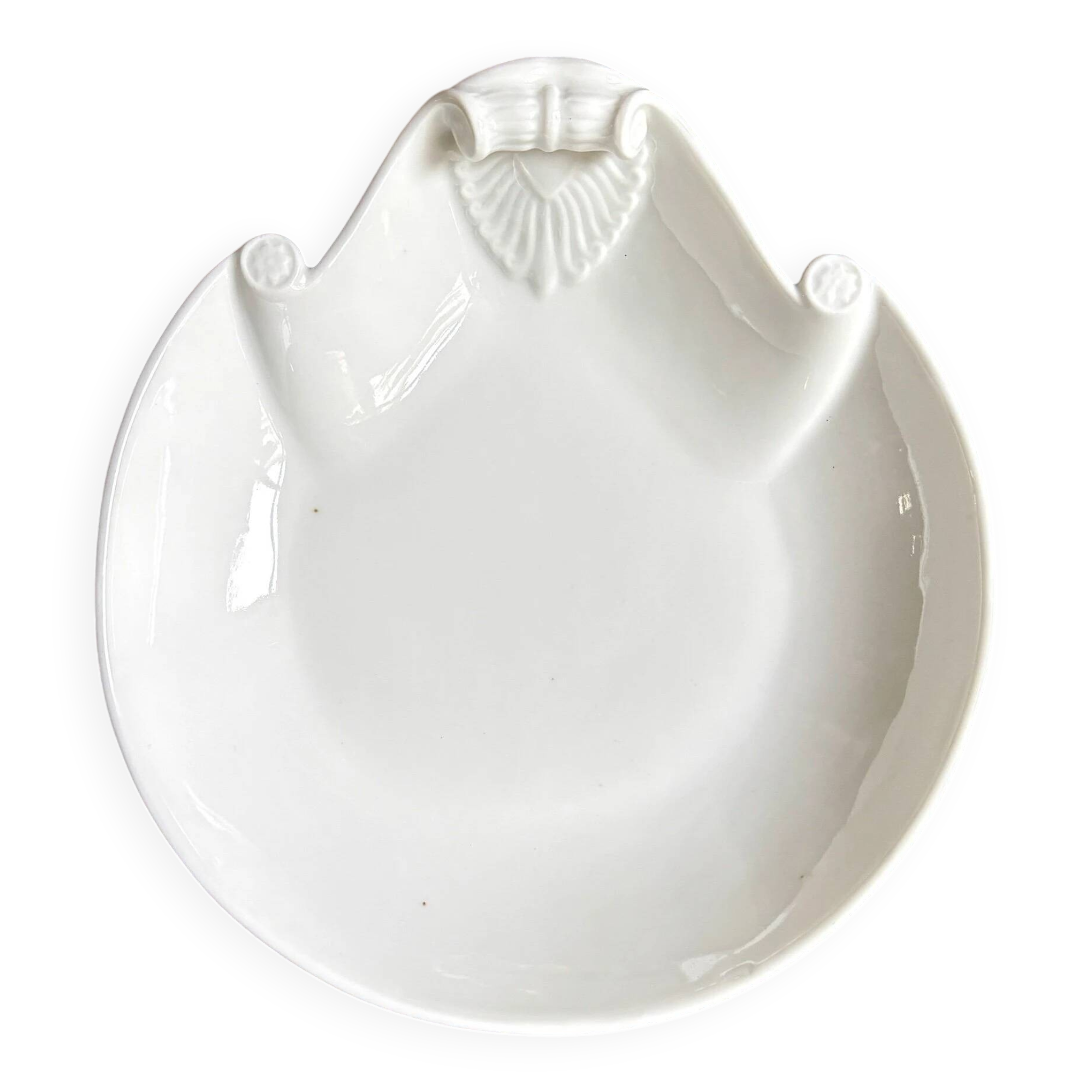 Small, shallow porcelain dish shaped like a seashell