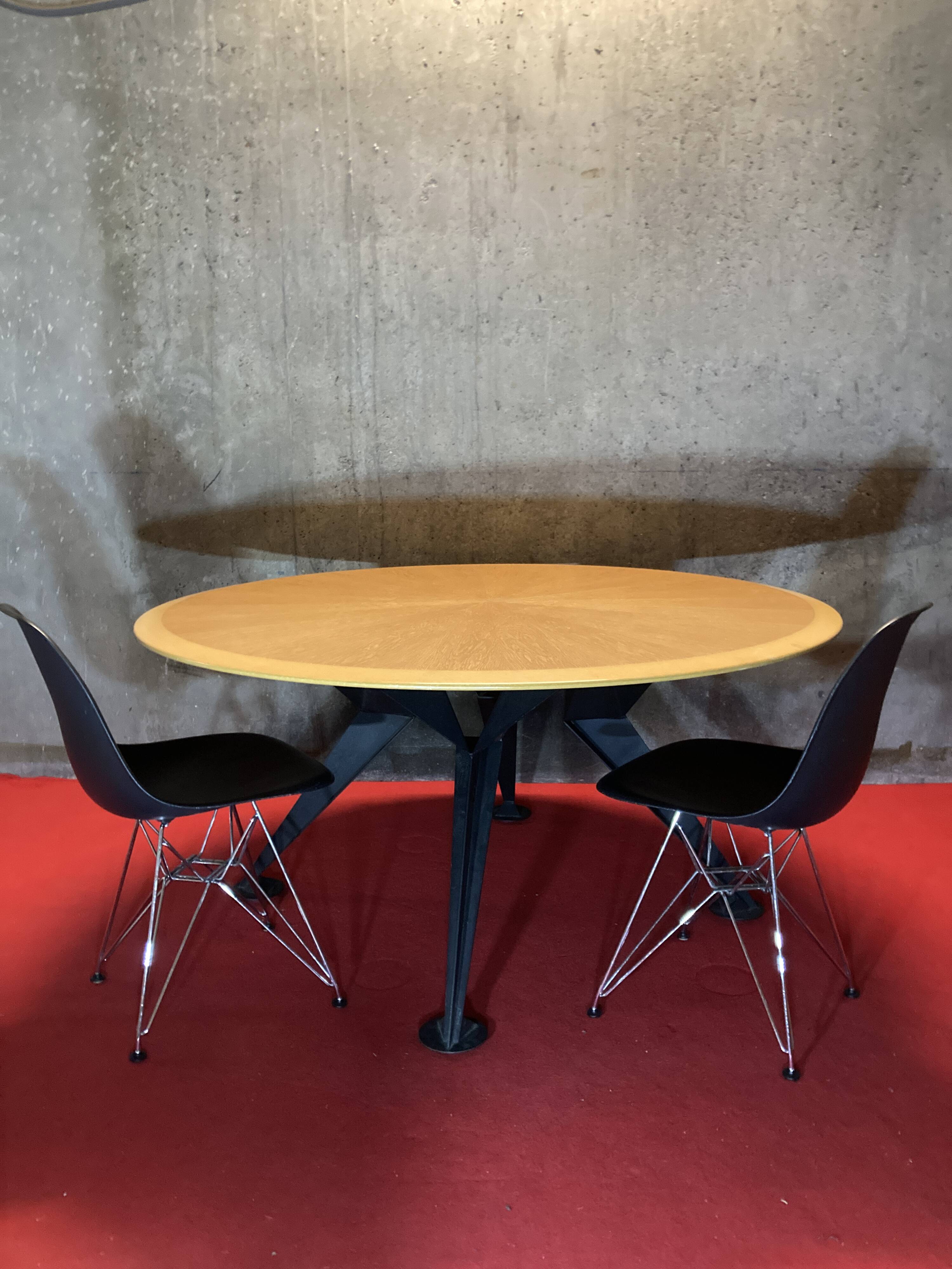 Round wooden and metal quadripod dining table