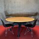 Round wooden and metal quadripod dining table