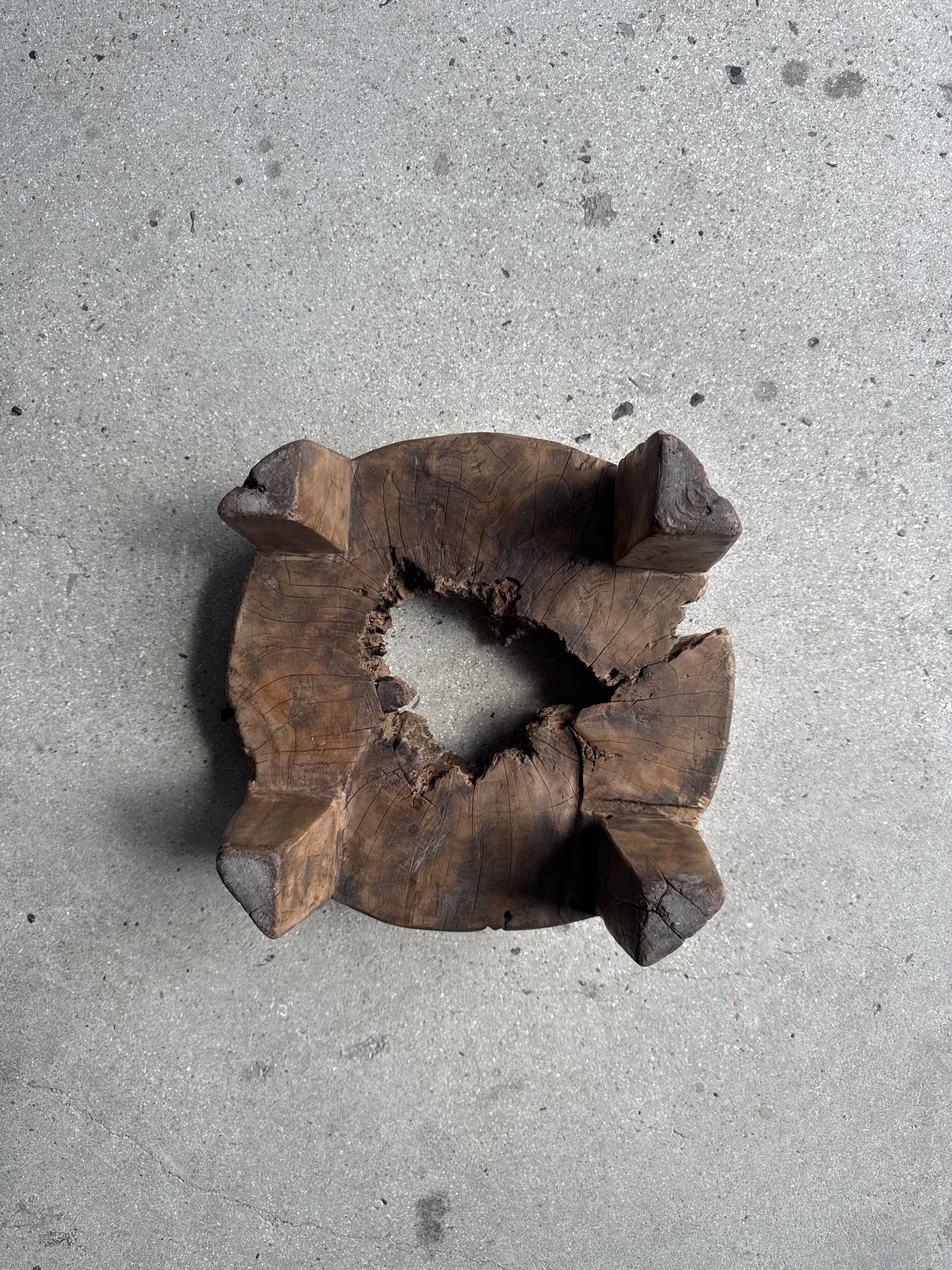 Small low circular four-legged stool in organic old teak with cut-out design H2