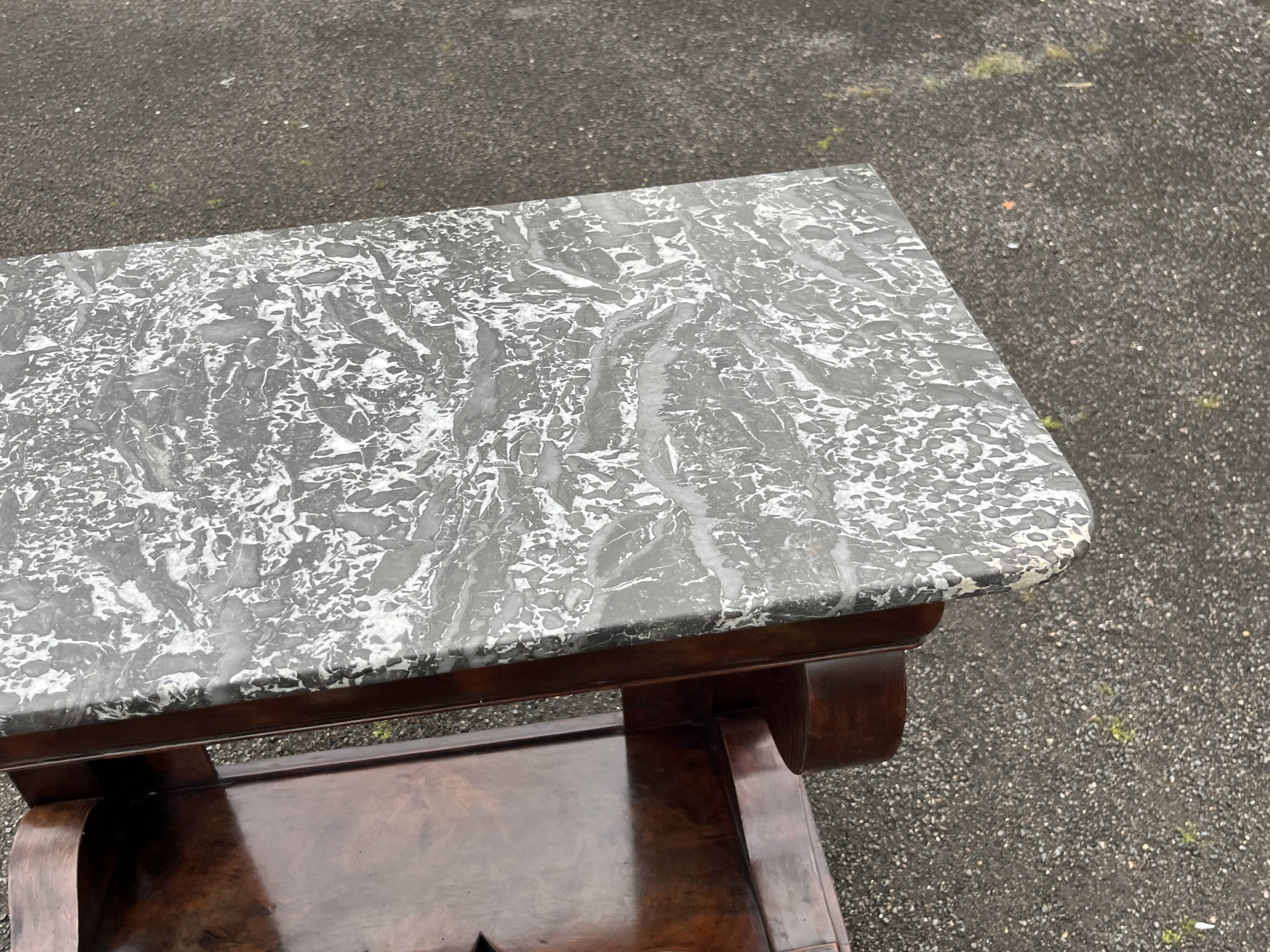Mahogany console with grey marble top and lion paw feet.