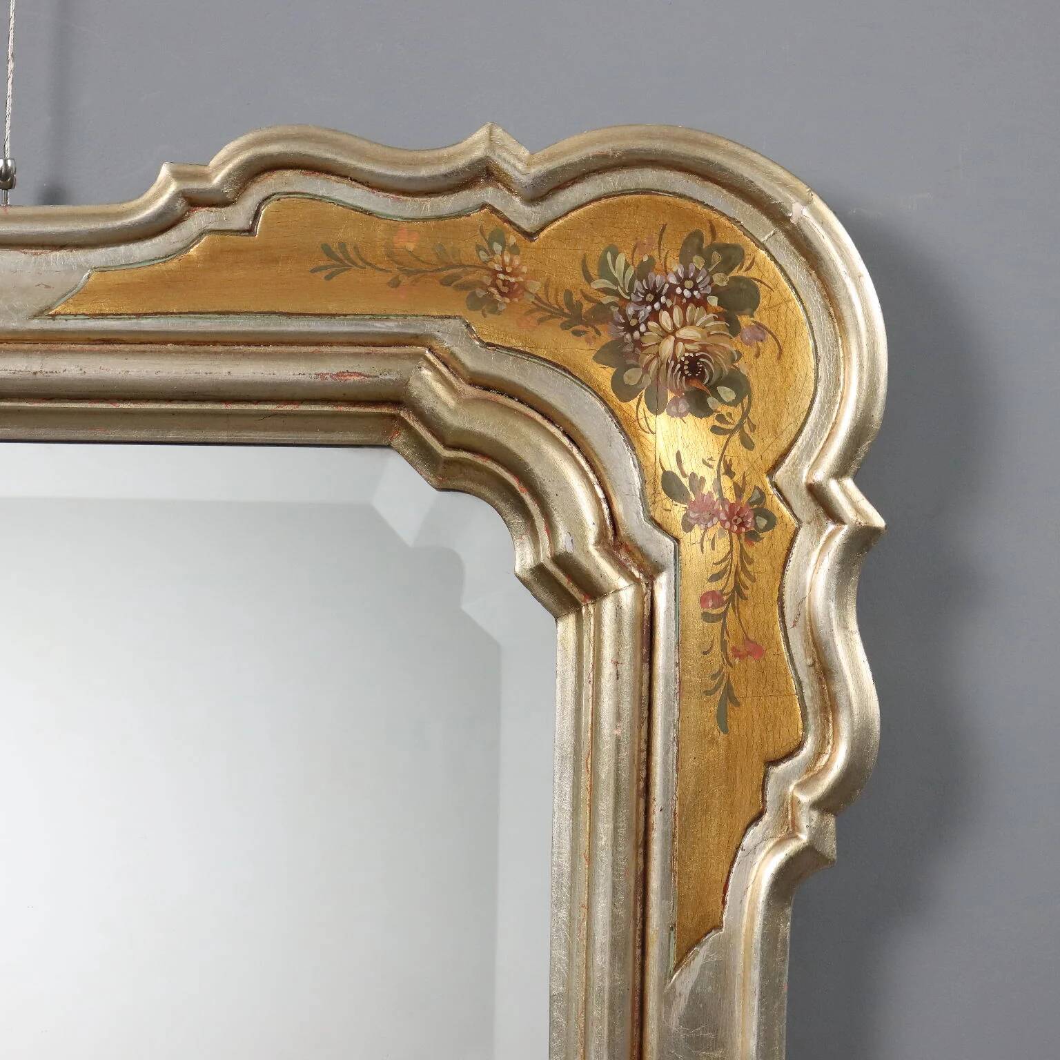 Antique mirror with a gilded frame and floral decorations, Italy, 20th century.