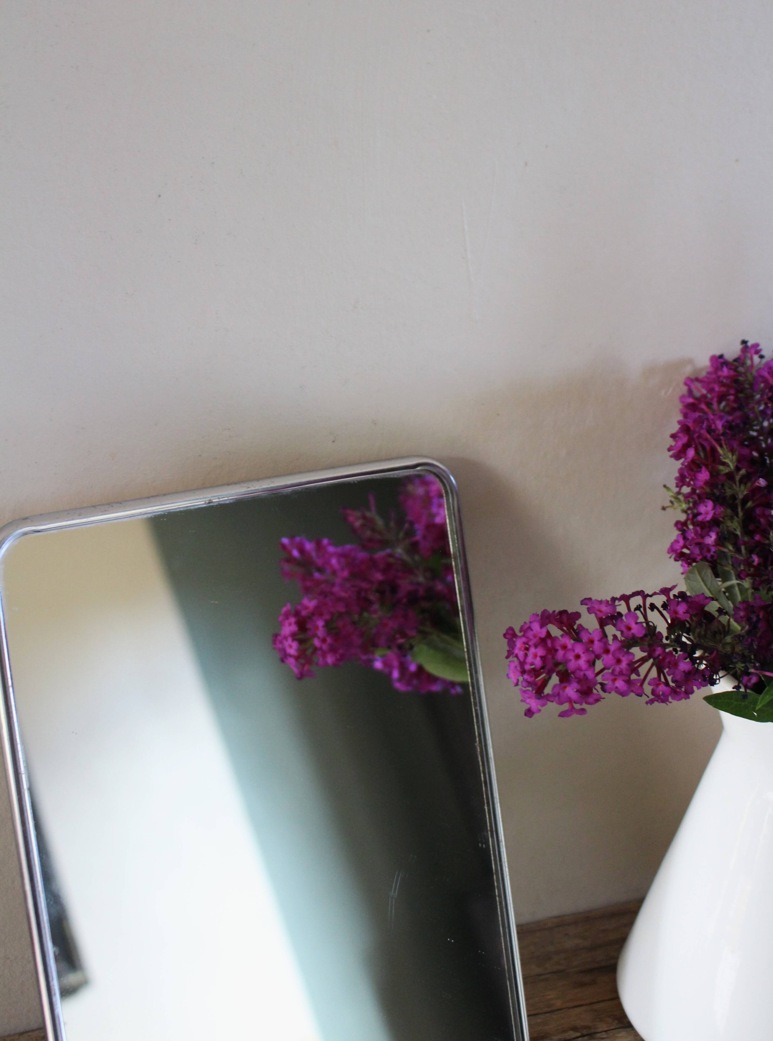 Simple rectangular barber mirror with a stand.