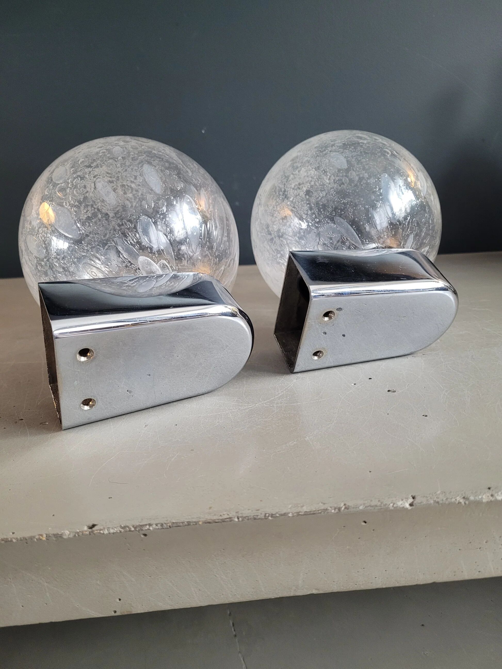 Pair of vintage wall lights in chrome metal with bubbled glass globes.
