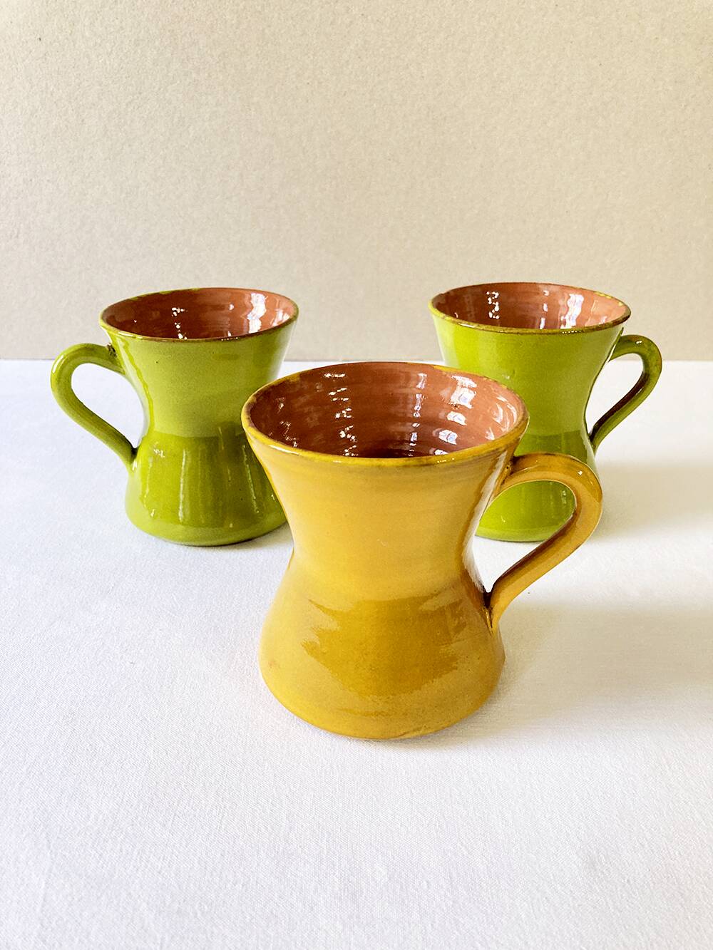 3 large green and yellow enameled ceramic cups, signed