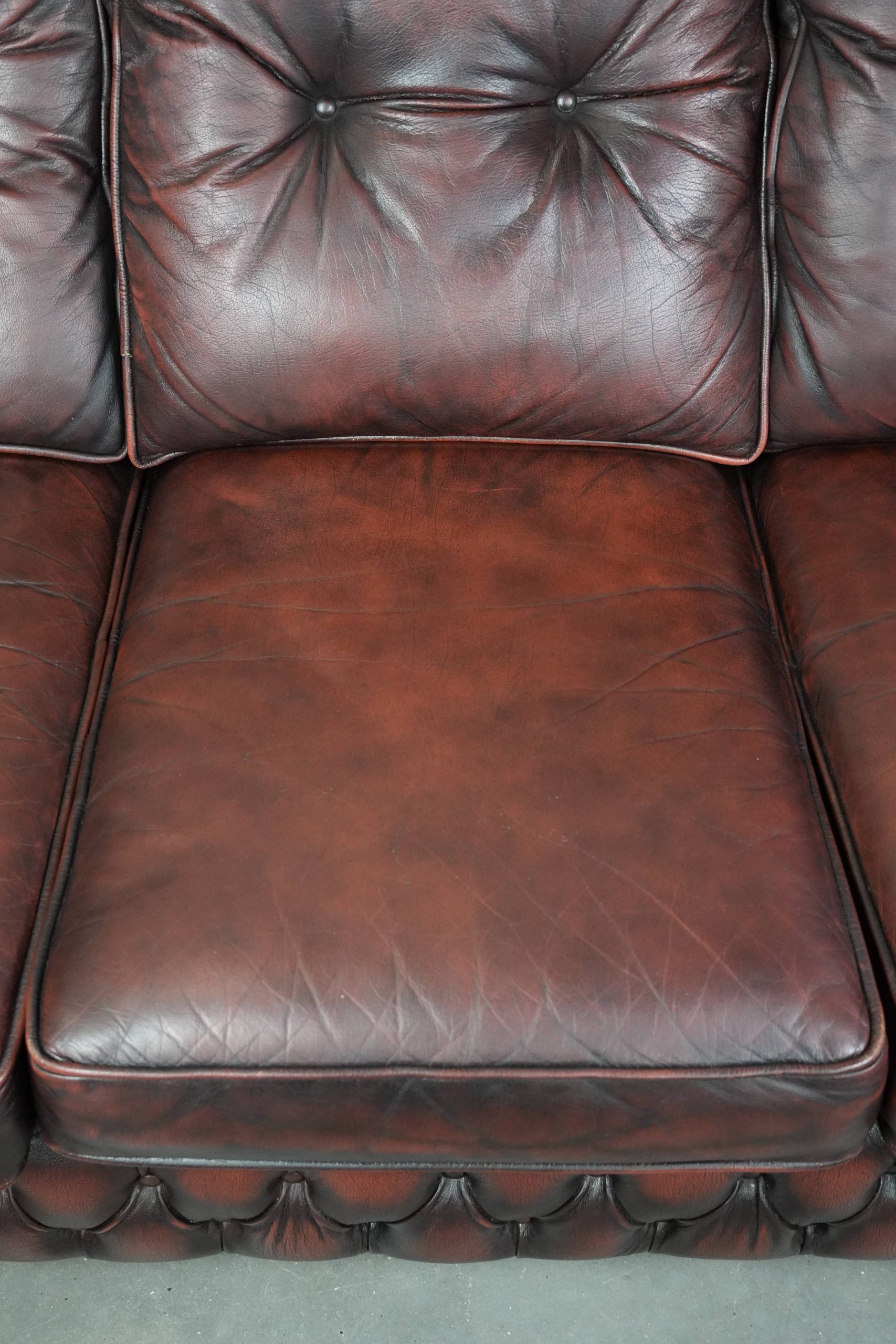 Red 2.5-seater Chesterfield sofa on wheels in English style