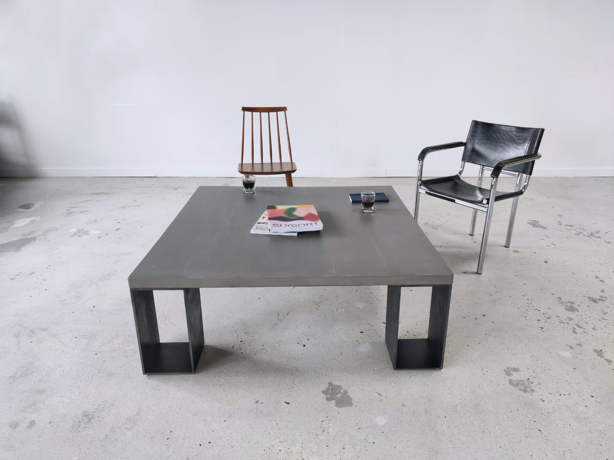 Table basse minimaliste en béton ciré et acier massif 1m20x1m20