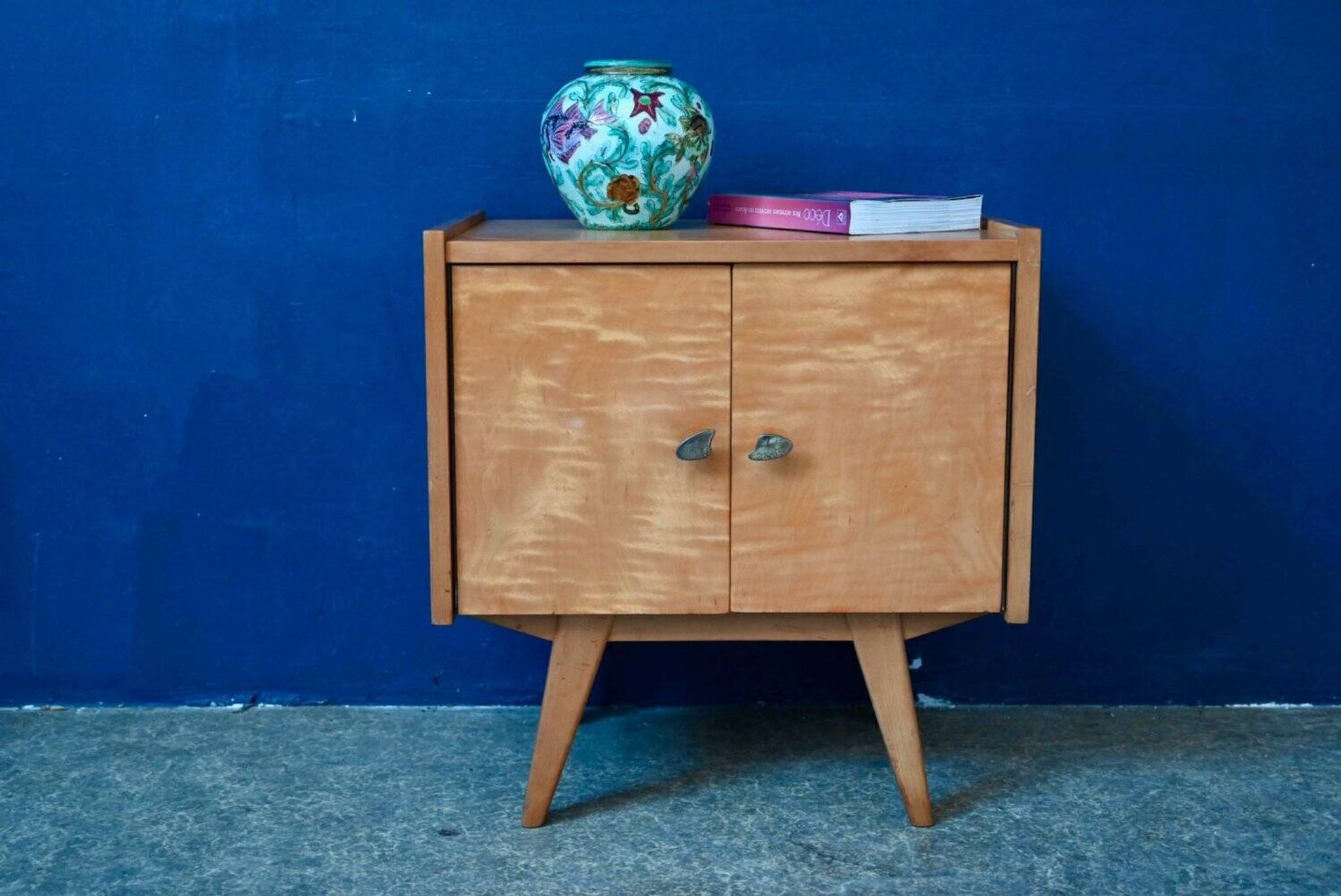 Rockabilly design bedside table with tapered legs.