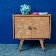 Rockabilly design bedside table with tapered legs.