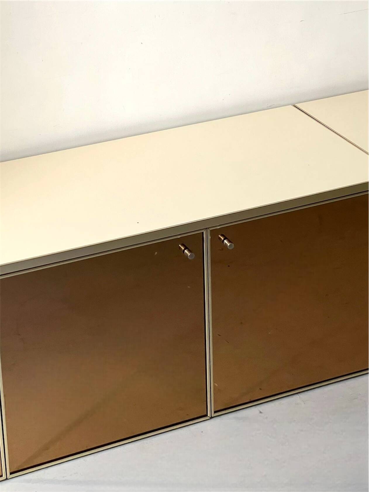 Low ivory lacquered enfilade, smoked mirror & brass JC Mahey, design 1970.