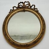 Antique oval gilded mirror with wooden frame and stucco detail