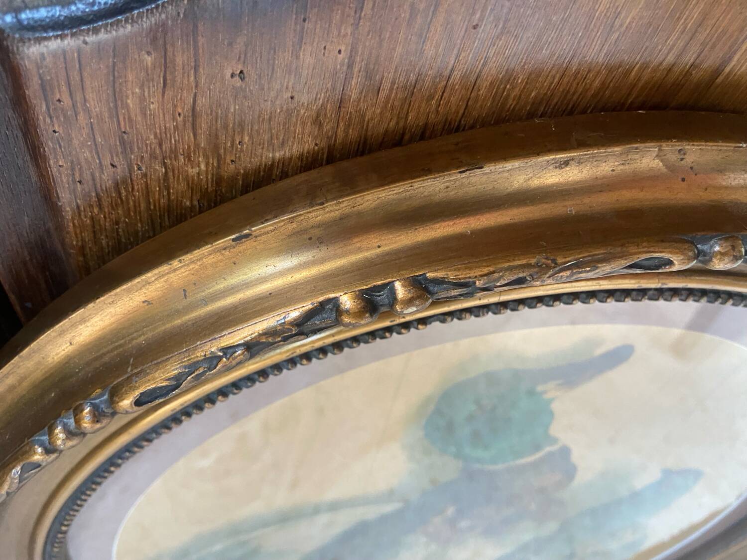 Antique oval frame with an oil painting of green collars