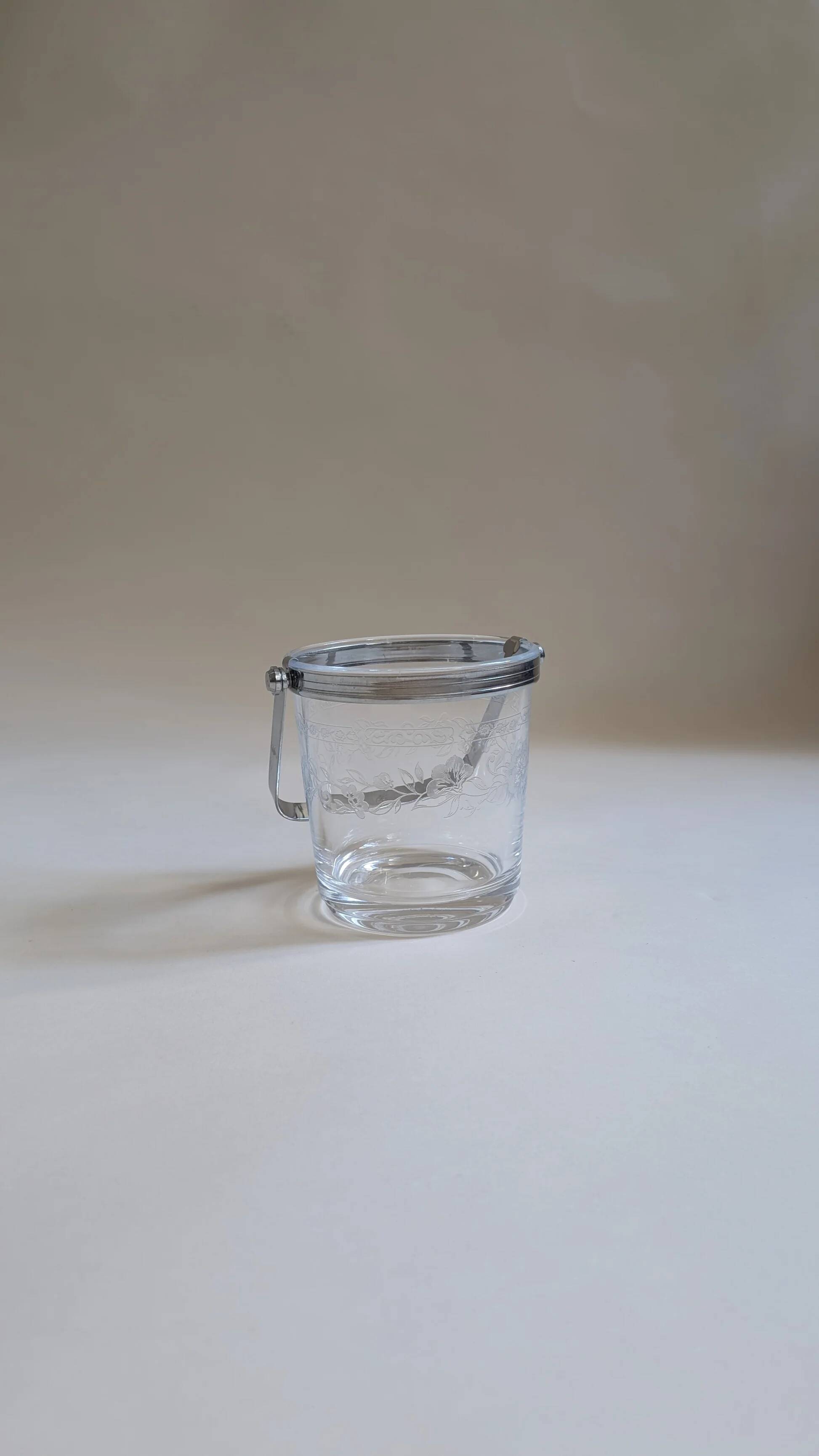 Clear glass ice bucket with an etched floral design