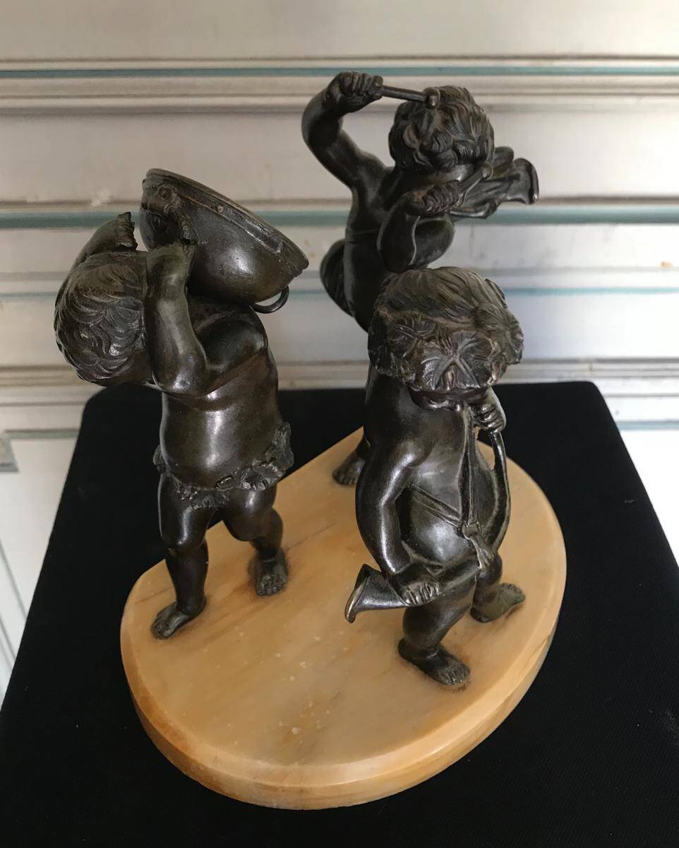 Three musician angels, bronze sculptures on a marble base.