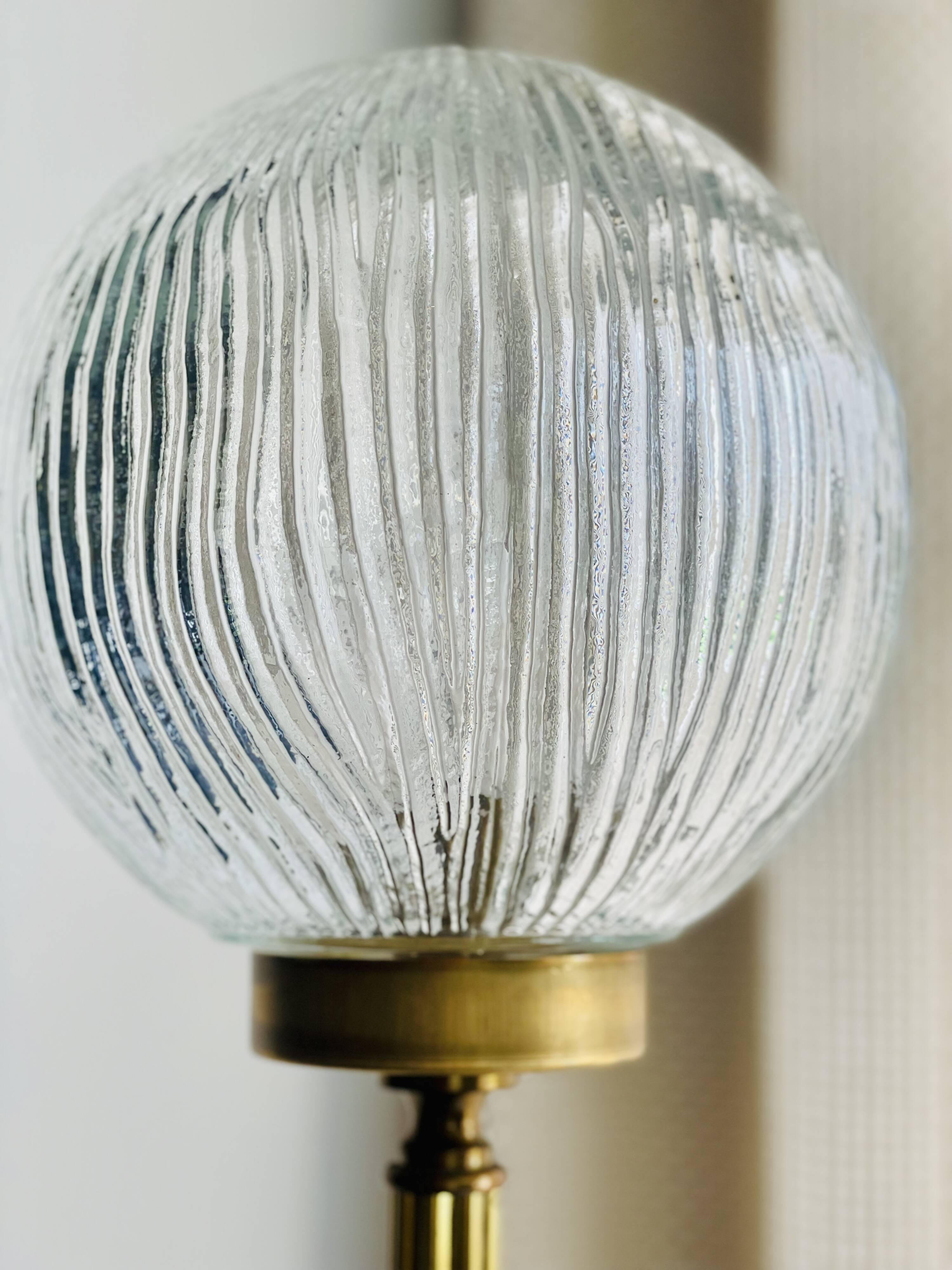 Floor lamp in gilded brass and round glass globe