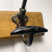 Antique wooden coat rack with metal hooks