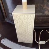 High foot of lace-up desing lamp, off-white background and beige patterns.