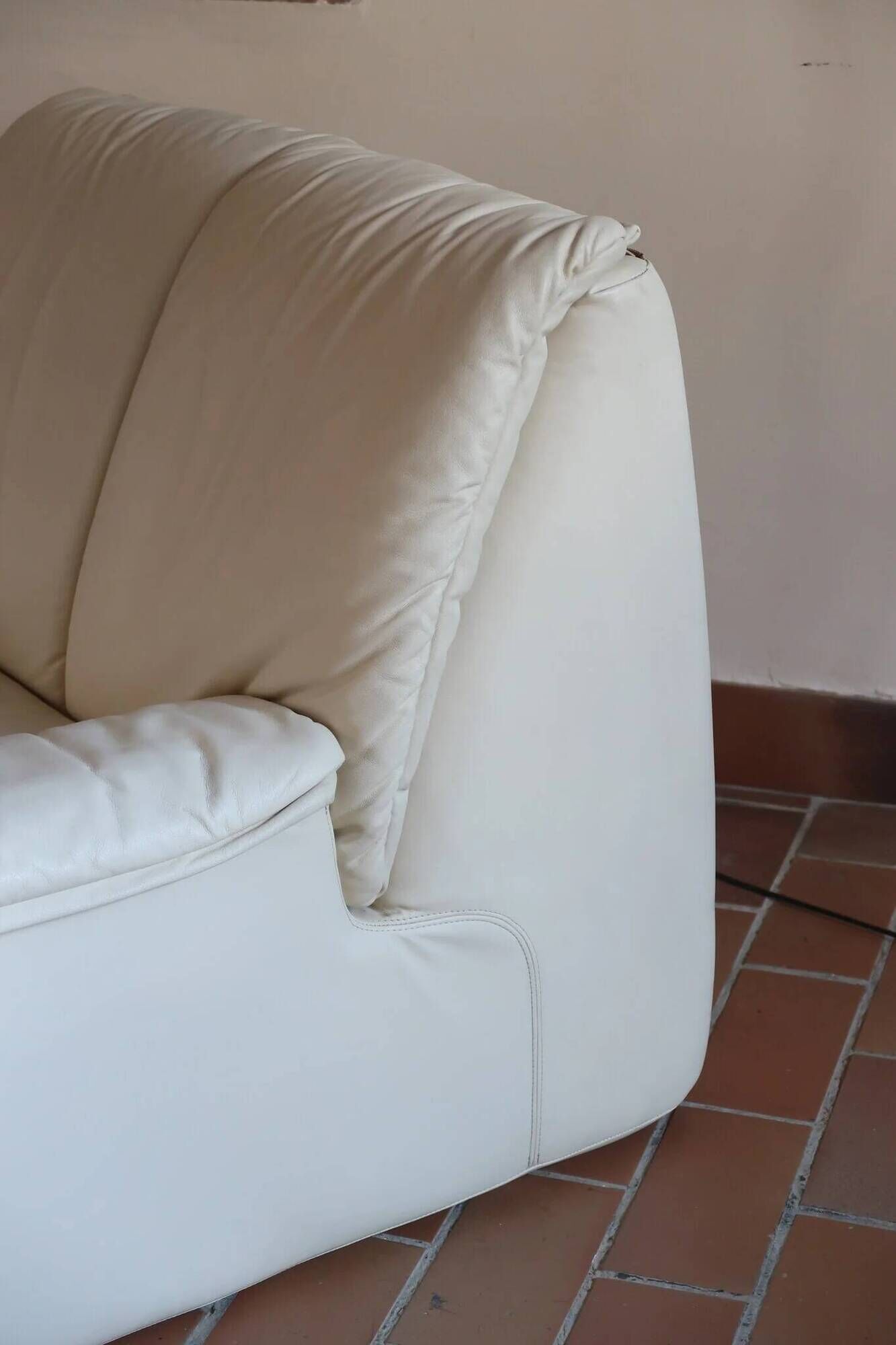 Cinna armchair in cream leather, bolstered armrests, 1970s.