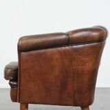 Fauteuil club en cuir de mouton foncé avec passepoil noir