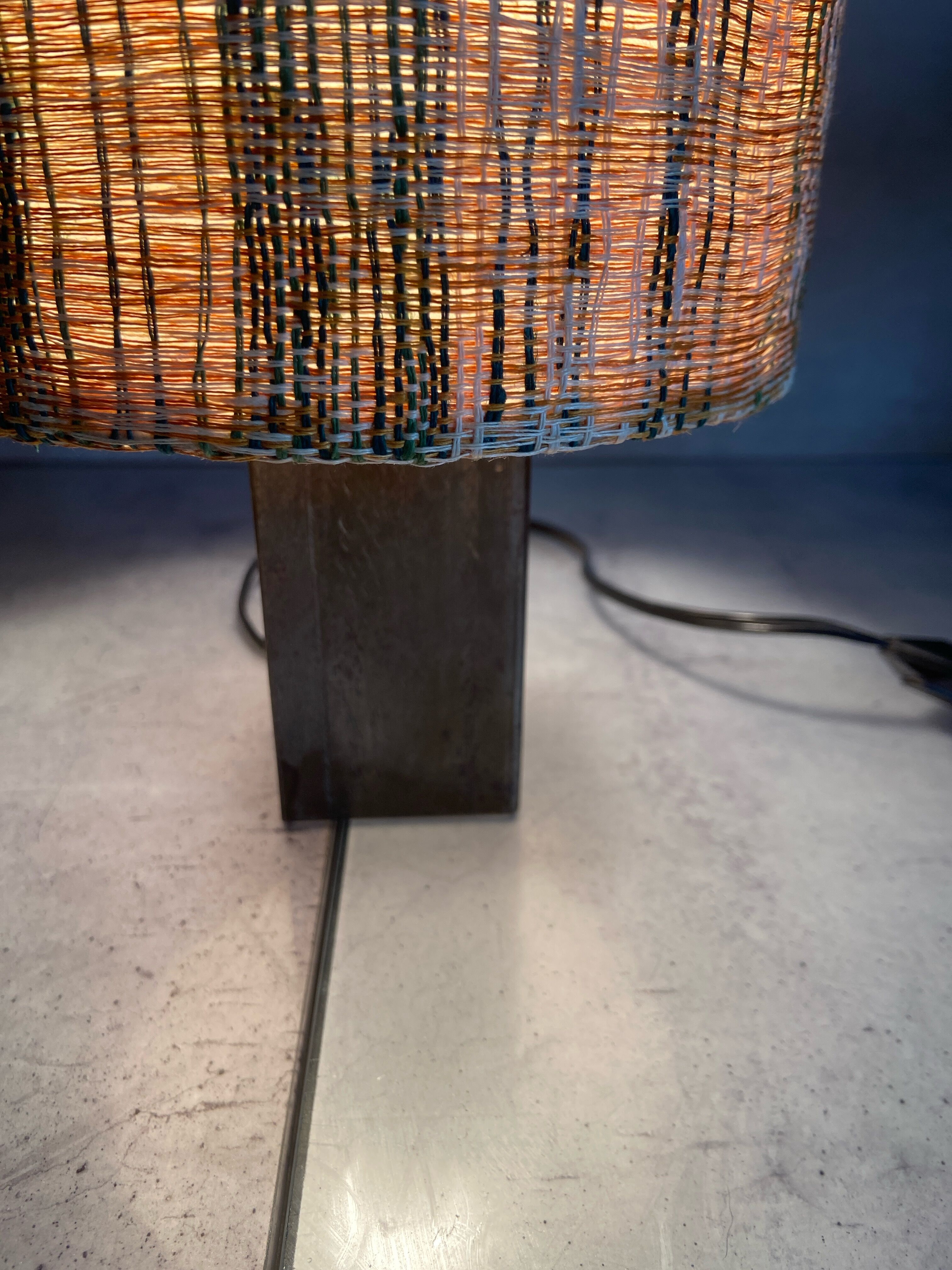 Small modernist table lamp with hand-woven shade.