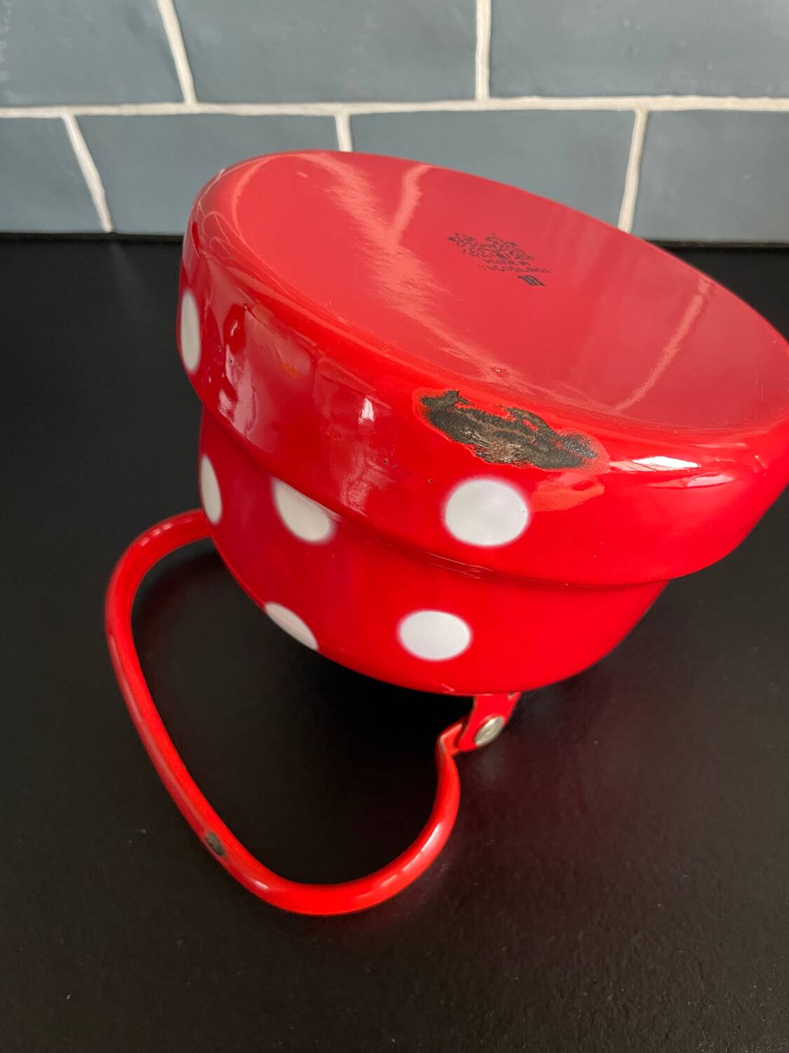 Red enameled sheet metal kettle with white polka dots