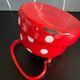 Red enameled sheet metal kettle with white polka dots