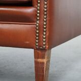 Correct, comfortable, luxurious English-style wingback armchair made of cognac-colored cow leather
