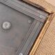 Large square vintage coffee table in wood, glass, and metal decor.