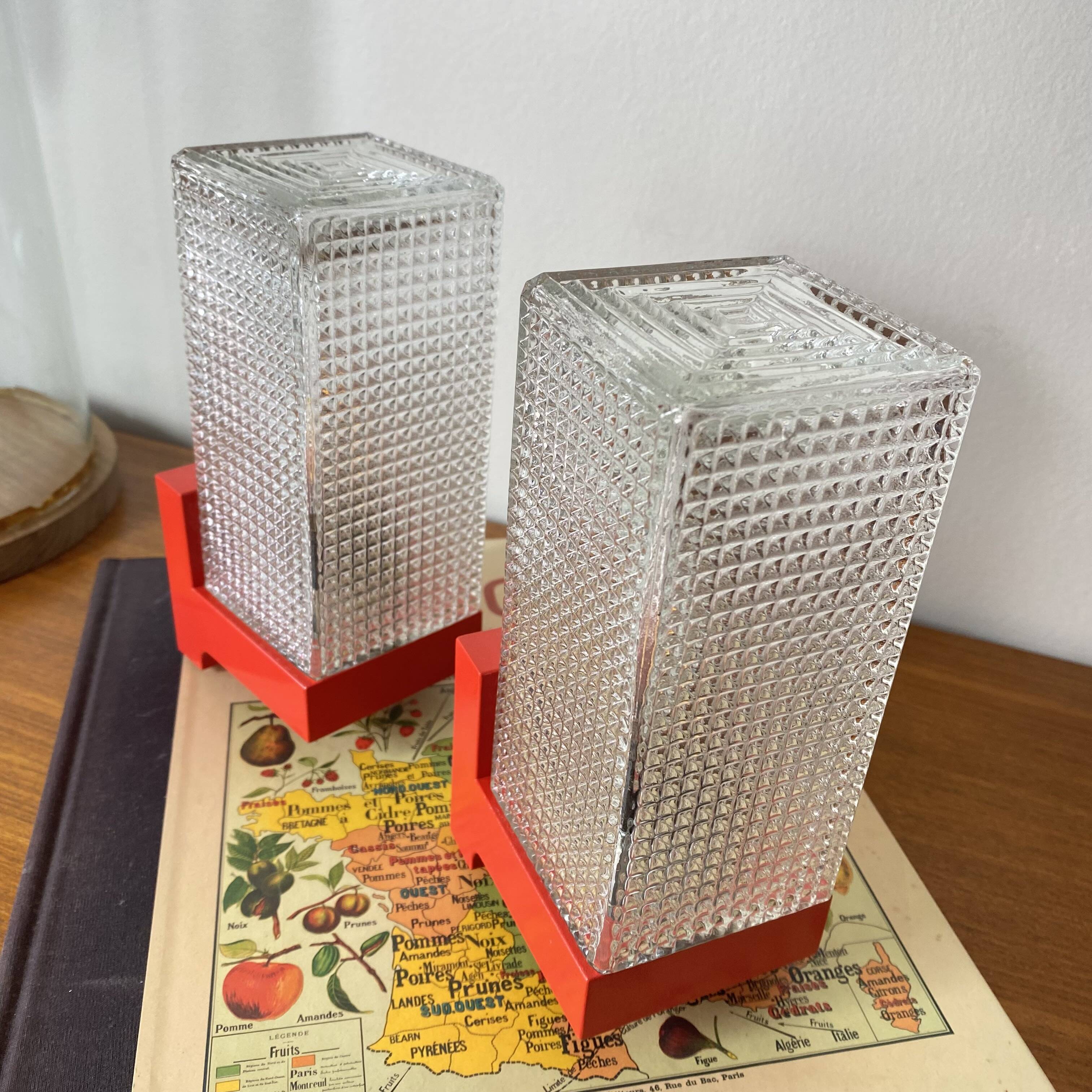 Pair of vintage wall lights in red plastic and clear glass.