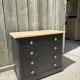 Antique commode with a matte black finish.