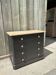 Antique commode with a matte black finish.