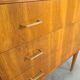 Commode danoise avec de hauts pieds et des poignées dorées.