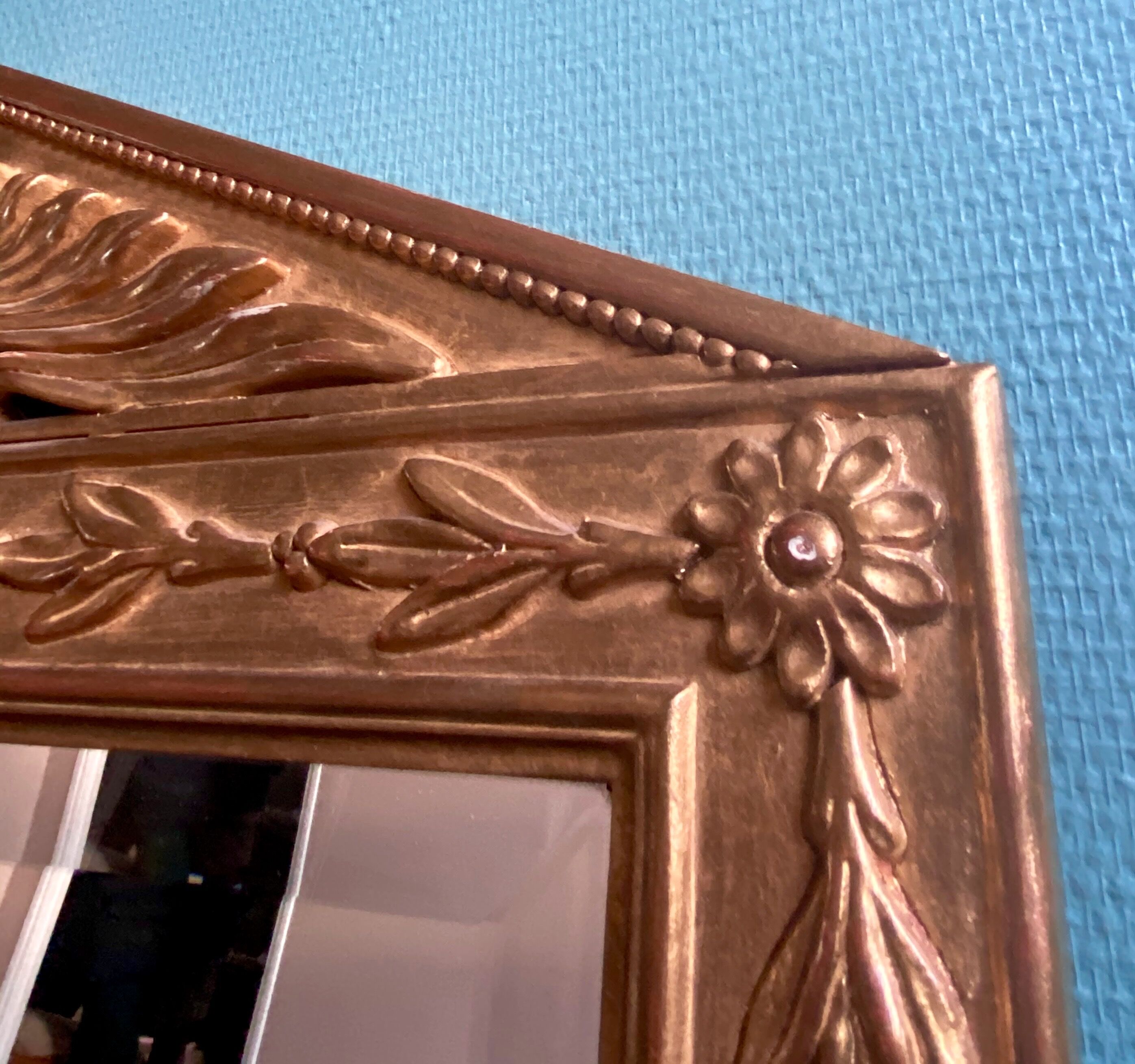 Mirror in gilded wood with a triangle pediment decorated with half sunflowers