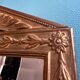 Mirror in gilded wood with a triangle pediment decorated with half sunflowers