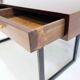 Wooden desk with drawers and black lacquered legs.