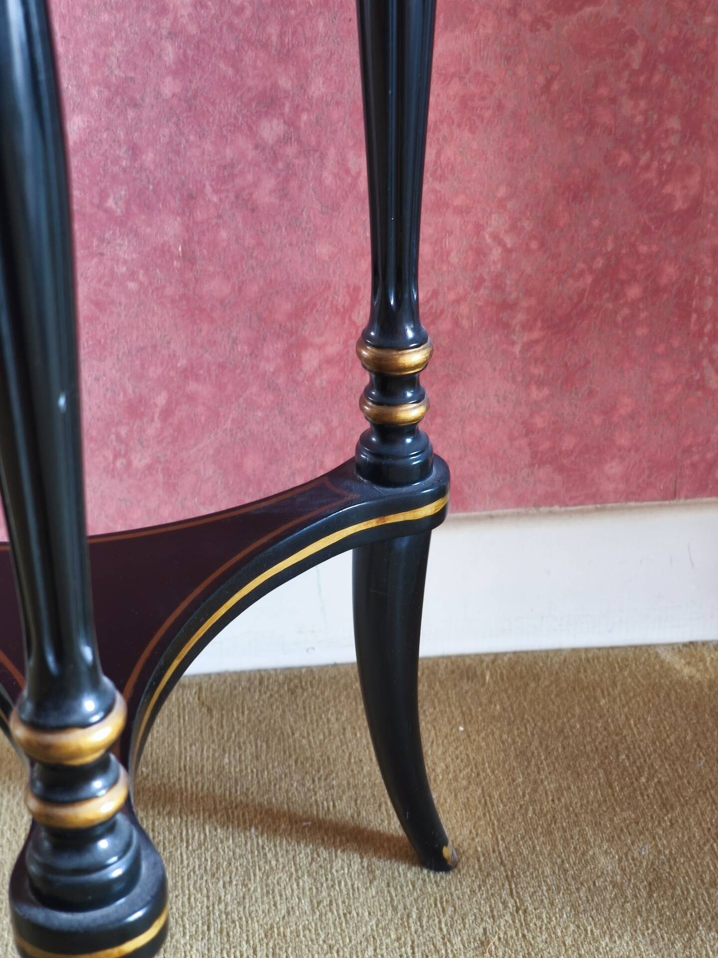 Tripod stool in blackened wood with painted floral decoration.