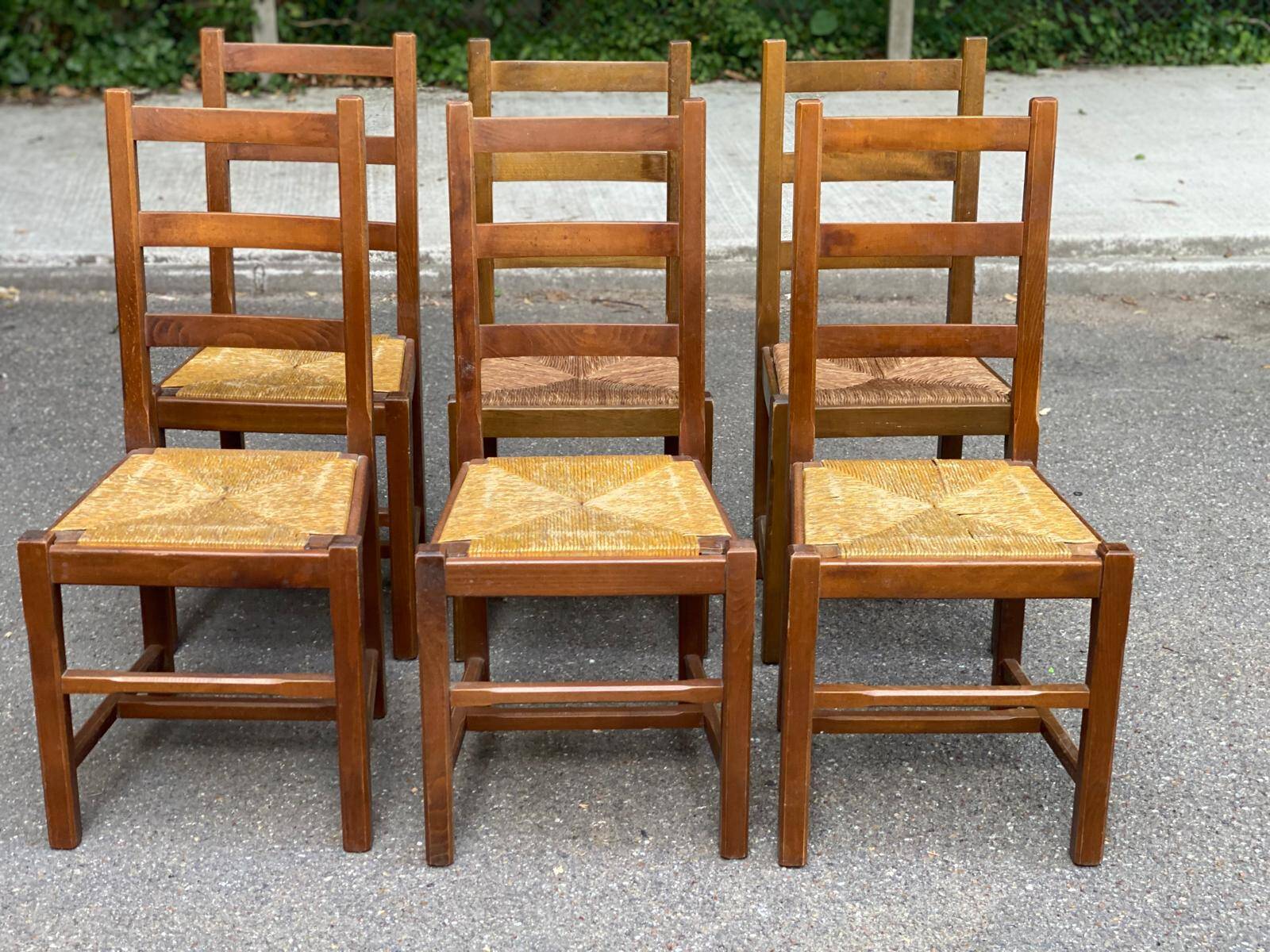 6 light solid wood chairs with high straw backs, farmhouse style.