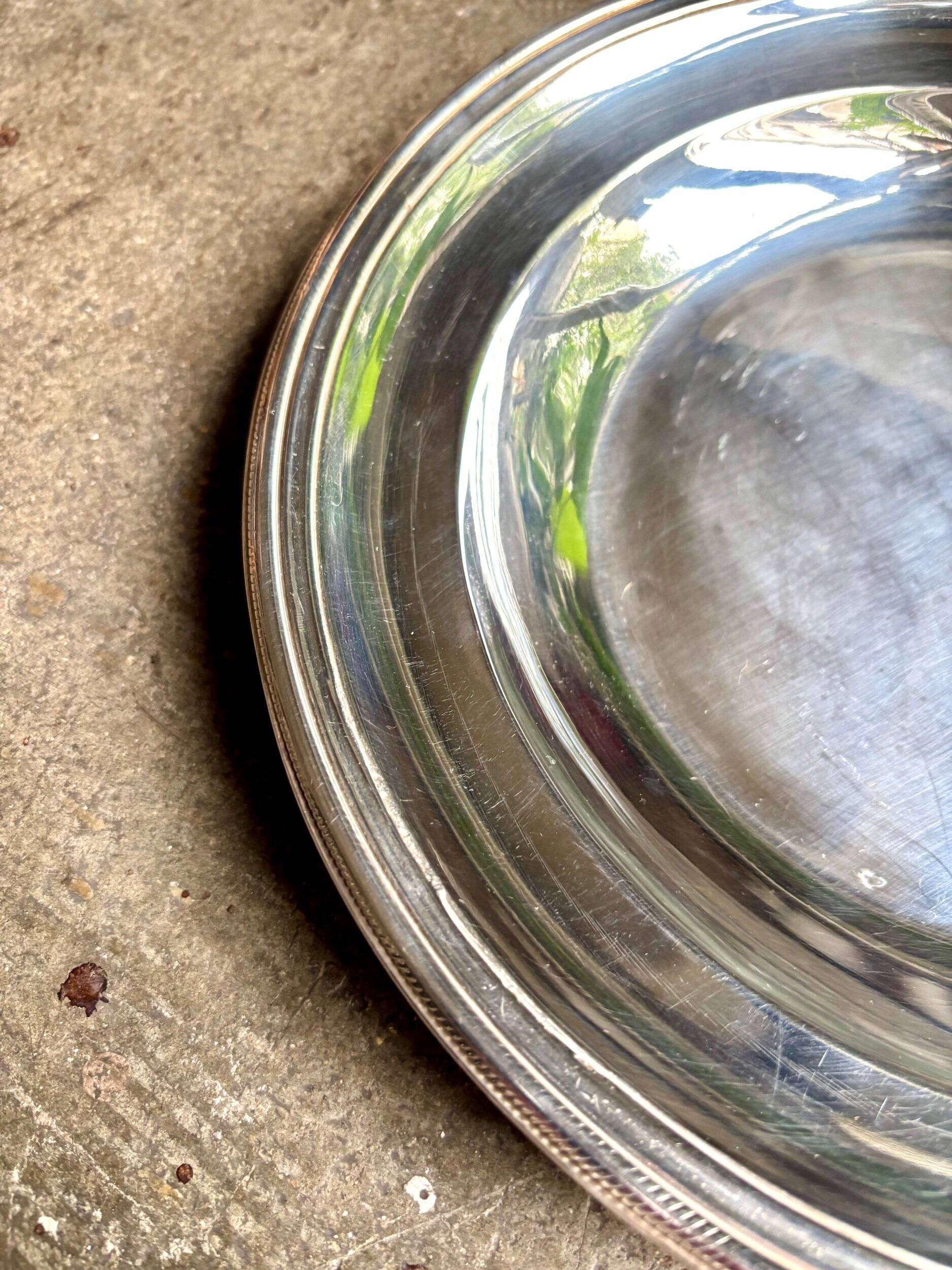 Round, hollow silver-plated metal dish