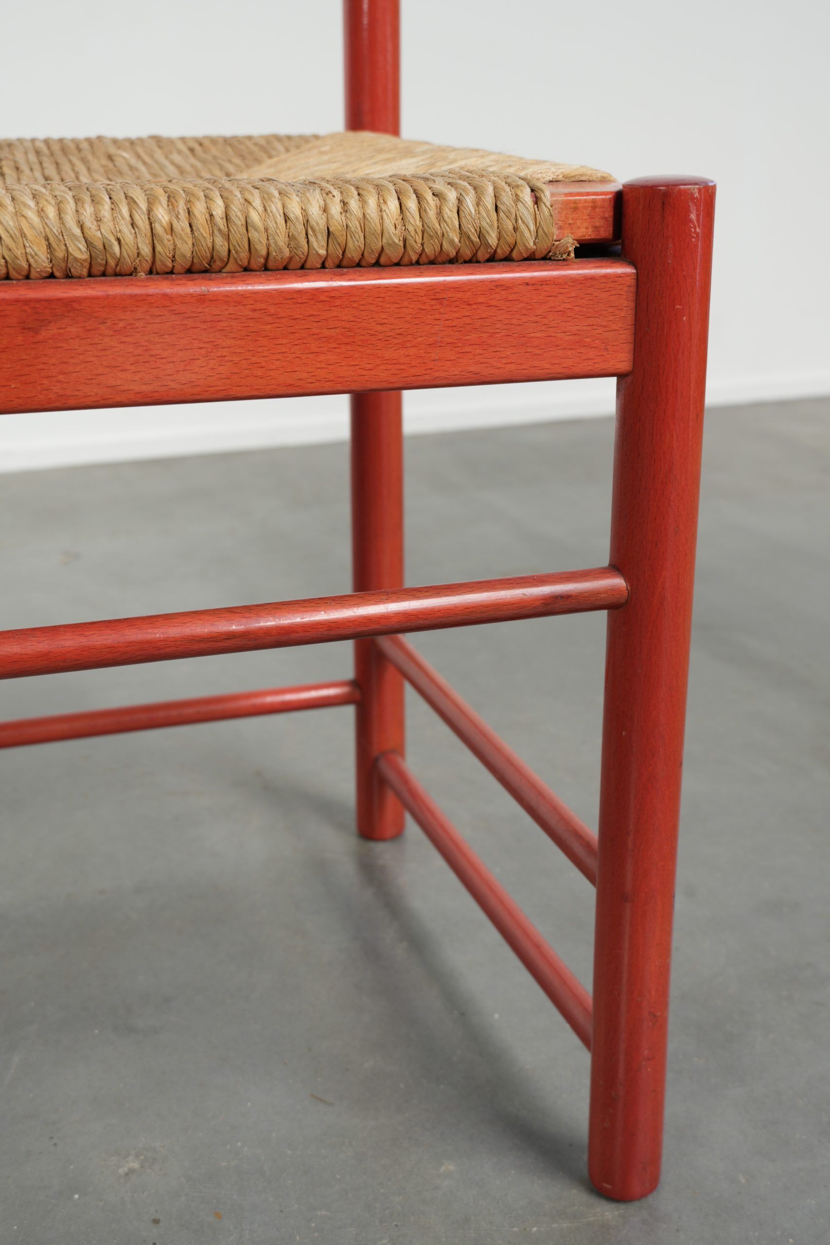 Red vintage wooden chair from the 1970s with a woven wicker seat