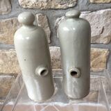 Lot of two old bottles of beige enamelled sandstone bottles