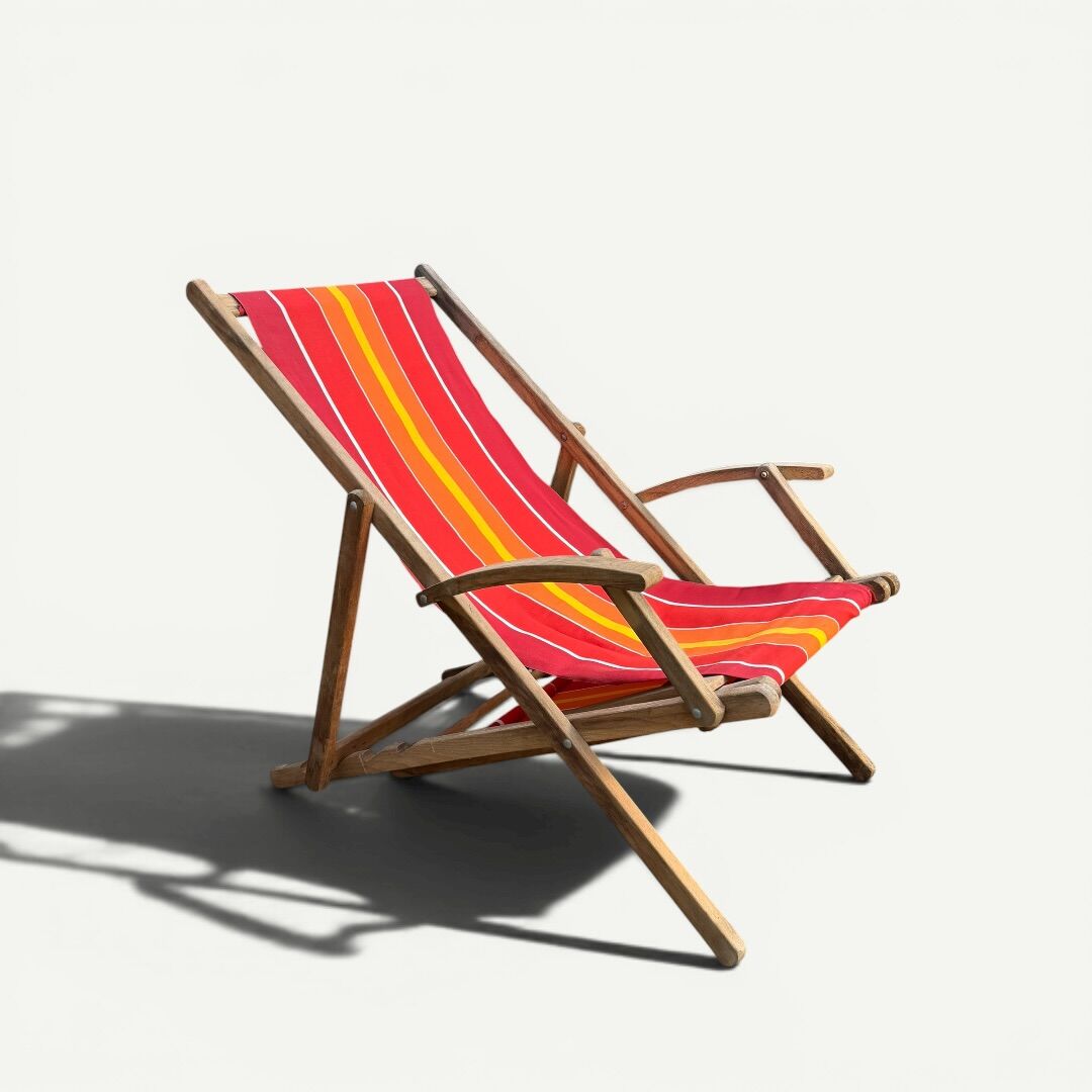 Vintage deck chair with red and orange striped fabric, original patina.